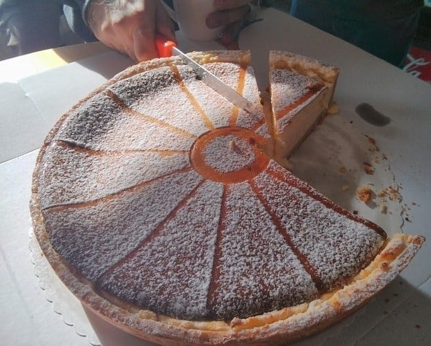 a pie with lines on top indicating where it should be cut, and a knife cutting into the pie at a different angle than what is visually indicated
